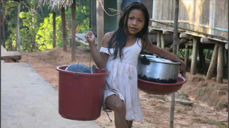 APRENDER HACIENDO. Niña matsés regresa a su casa, después de ayudar a su familia, ocupándose de lavar platos y olla en el río. [imagen 1]